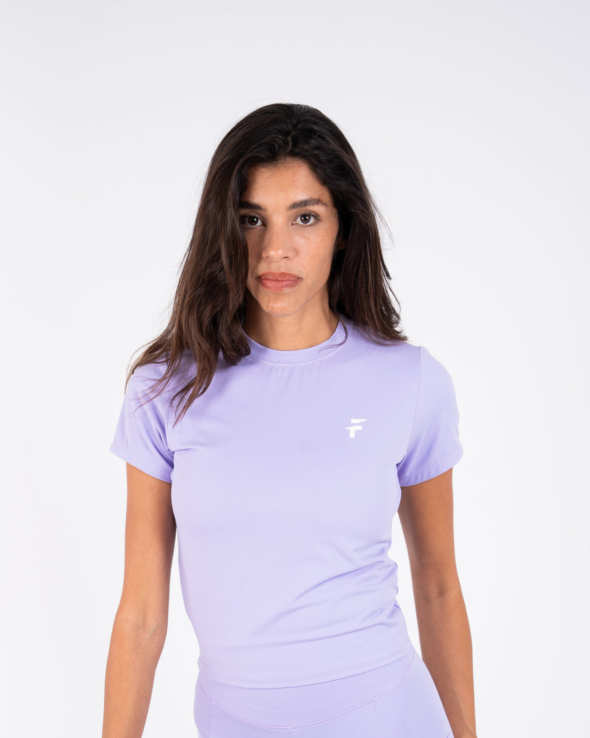 Woman wearing a light purple athletic outfit with a logo on a white background